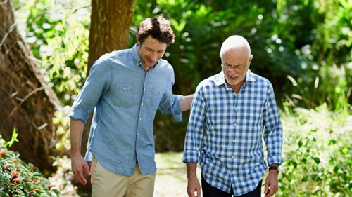 Sohn unterhält sich mit an IgAN erkrankten Vater beim Spaziergang im Wald 
