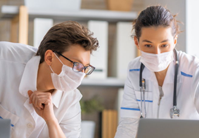 Arzt unterhält sich mit Kollegin über der Verlauf der IgA-Nephropathie Arzt unterhält sich mit Kollegin über der Verlauf der IgA-Nephropathie